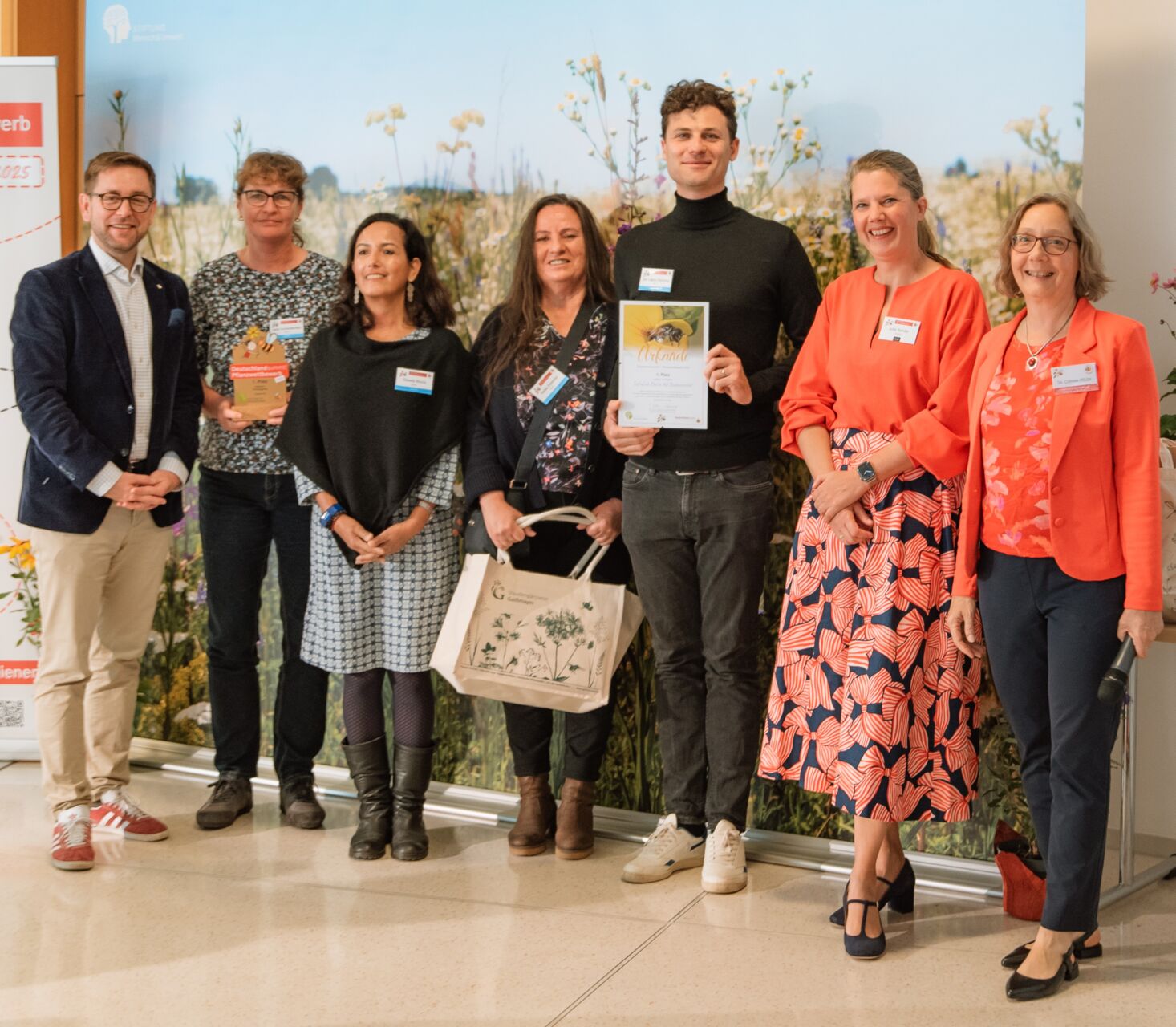 Deutschland summt!-Pflanzwettbewerb: Stiftungsleiterin Dr. Corinna Hölzer (re.), Wettbewerbsleiterin Julia Sander (2. v. re.) und Staatssekretär Andreas Kraus (li.) ehren eine Gewinnergruppe.